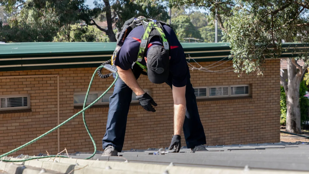 Inspector checking the integrity of a roof anchor.