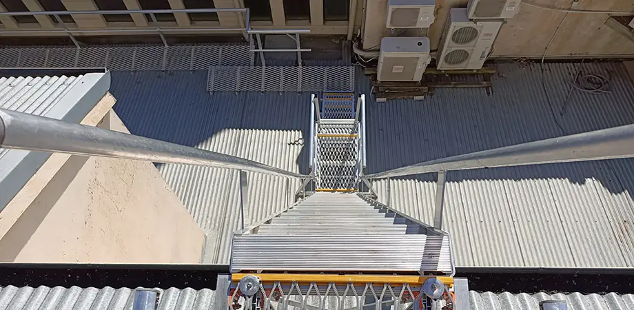 Looking down a set of stairs to the below landing platform and walkway at the Royal Exhibition Building, Melbourne.