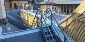 Pitched roofs with many stairs and ladders for access on them.
