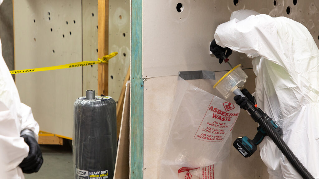 Participant in working with asbestos training cleaning tools post-use.