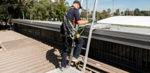 Technician accessing the roof of a community sport facility.