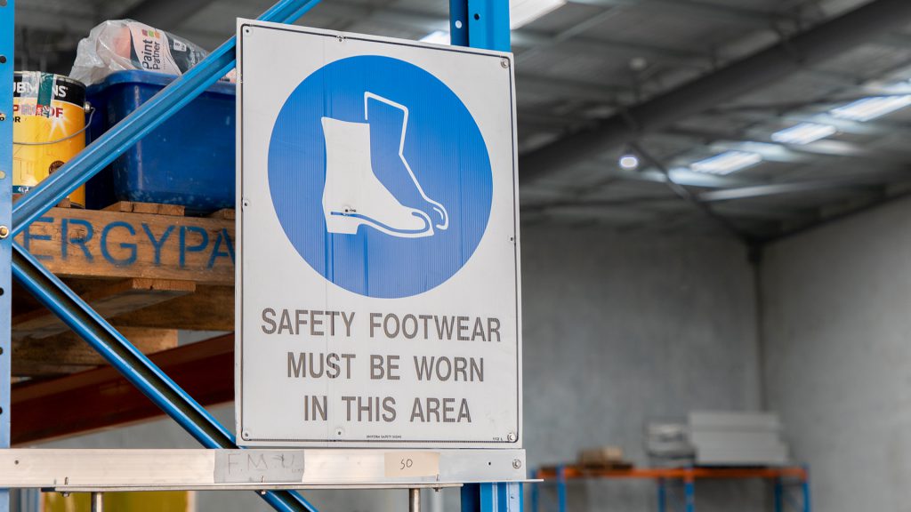 Warning sign indicating that protective footwear must be worn.