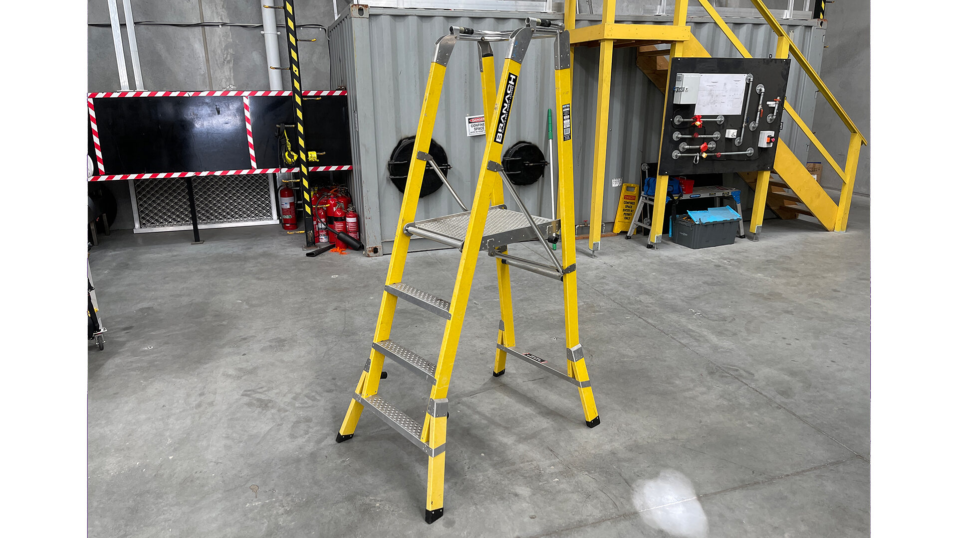 Portable step-type ladder on a warehouse floor.