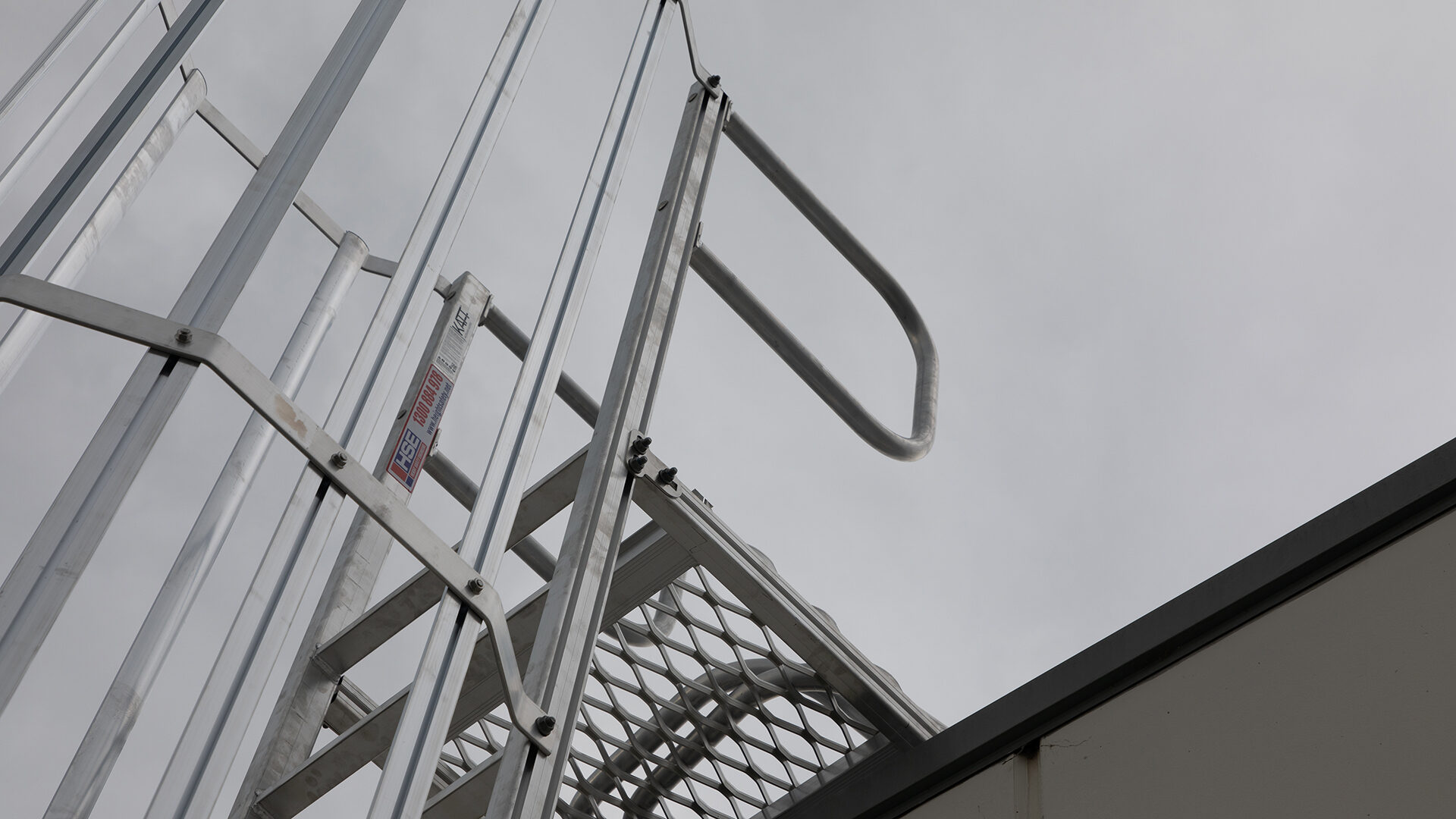Fixed ladder leading to a landing platform with grab rails.