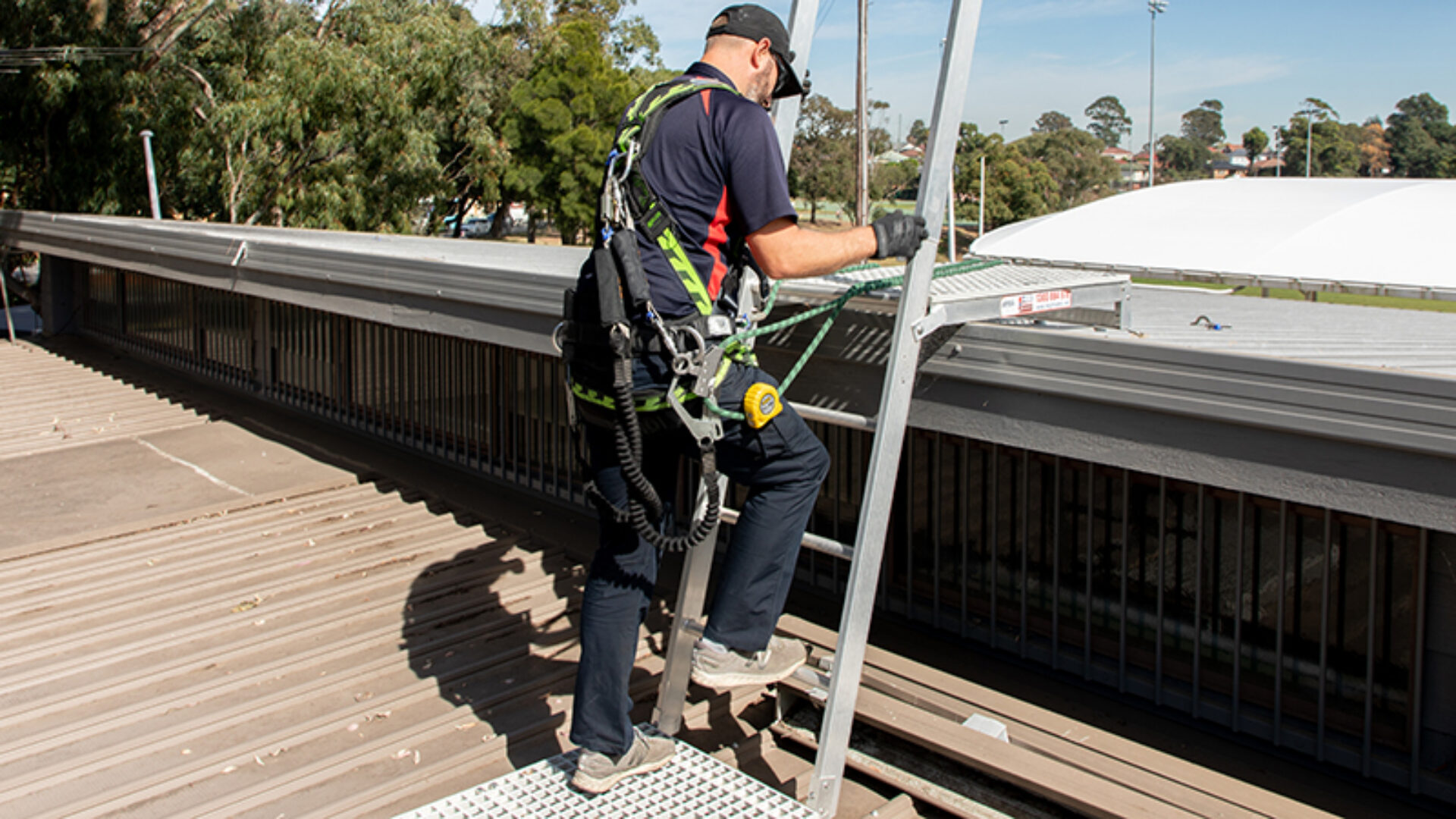 Technician accessing the roof of a community sport facility.