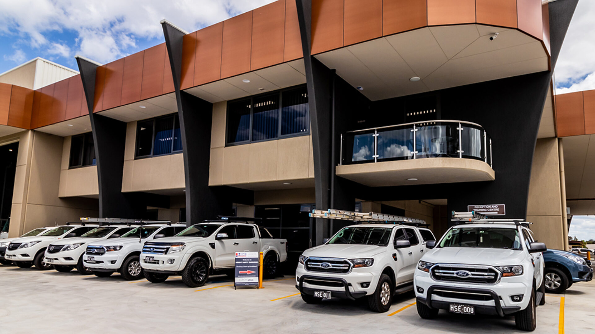 Front facade of the HSE Sydney office with many trucks parked out the front.
