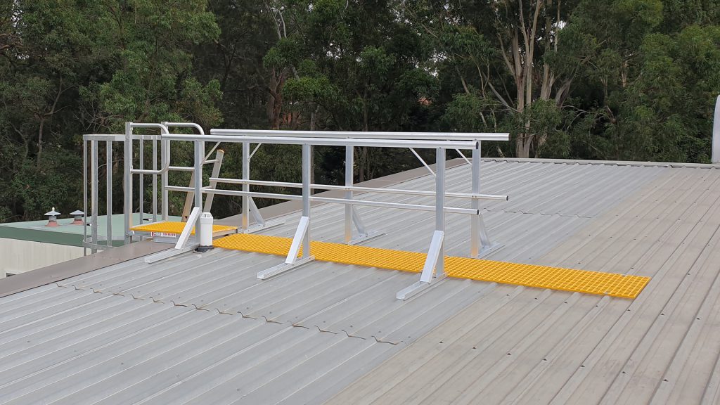 Walkway and guardrail for roof access off the top of a fixed ladder.