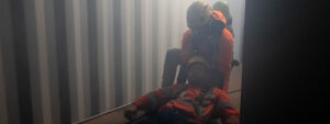Recovering a casualty from a confined space using breathing apparatus.