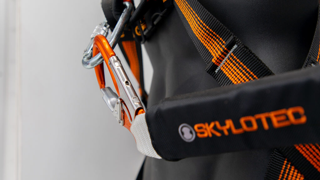 Skylotech shock absorber attached by karabiner to a fall arrest harness.
