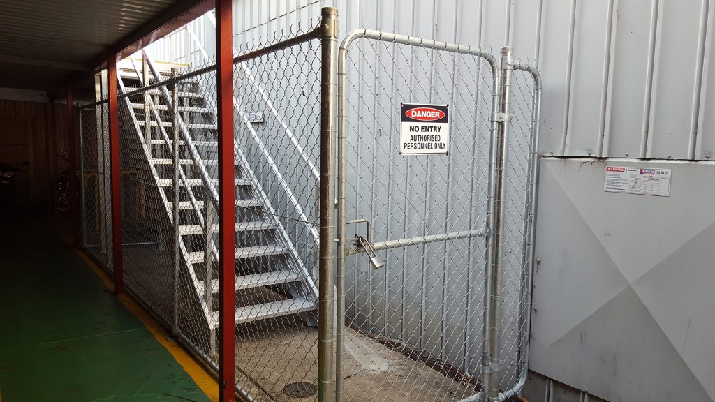 Stair case with restrcited access via a closed and locked wire mesh gate.