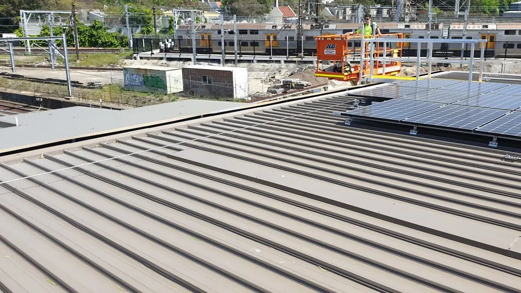 Access platform and static line safety system for solar panel access and gutter cleaning at a train maintenance facility in Sydney.