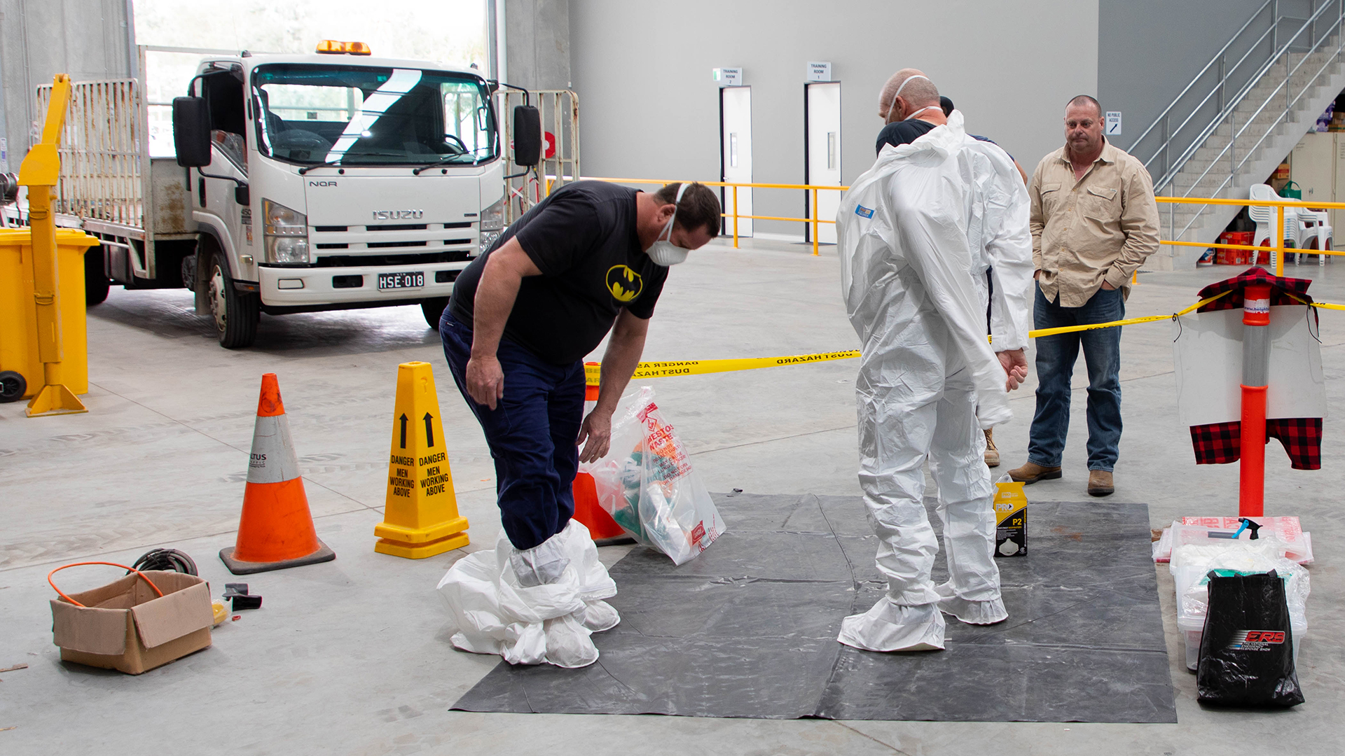 Training participants decontaminating themselves following asbestos removal.