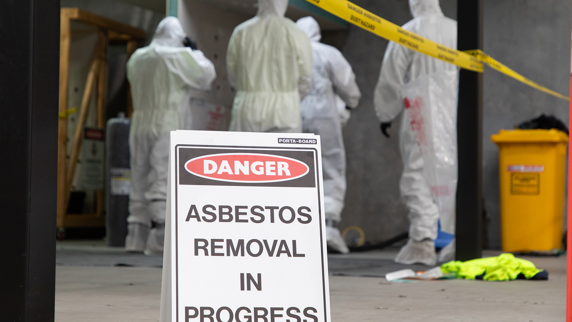 Warning sign stating that asbestos removal is taking place in the vicinity.
