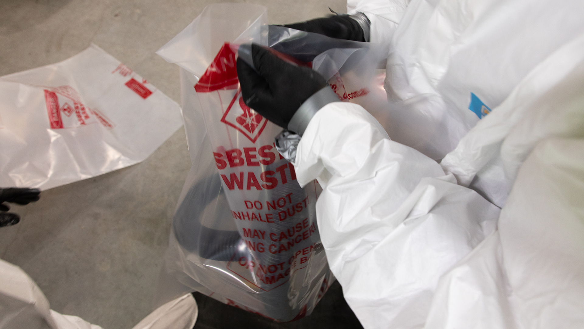 Course participant bagging tools that have been used in asbestos removal.