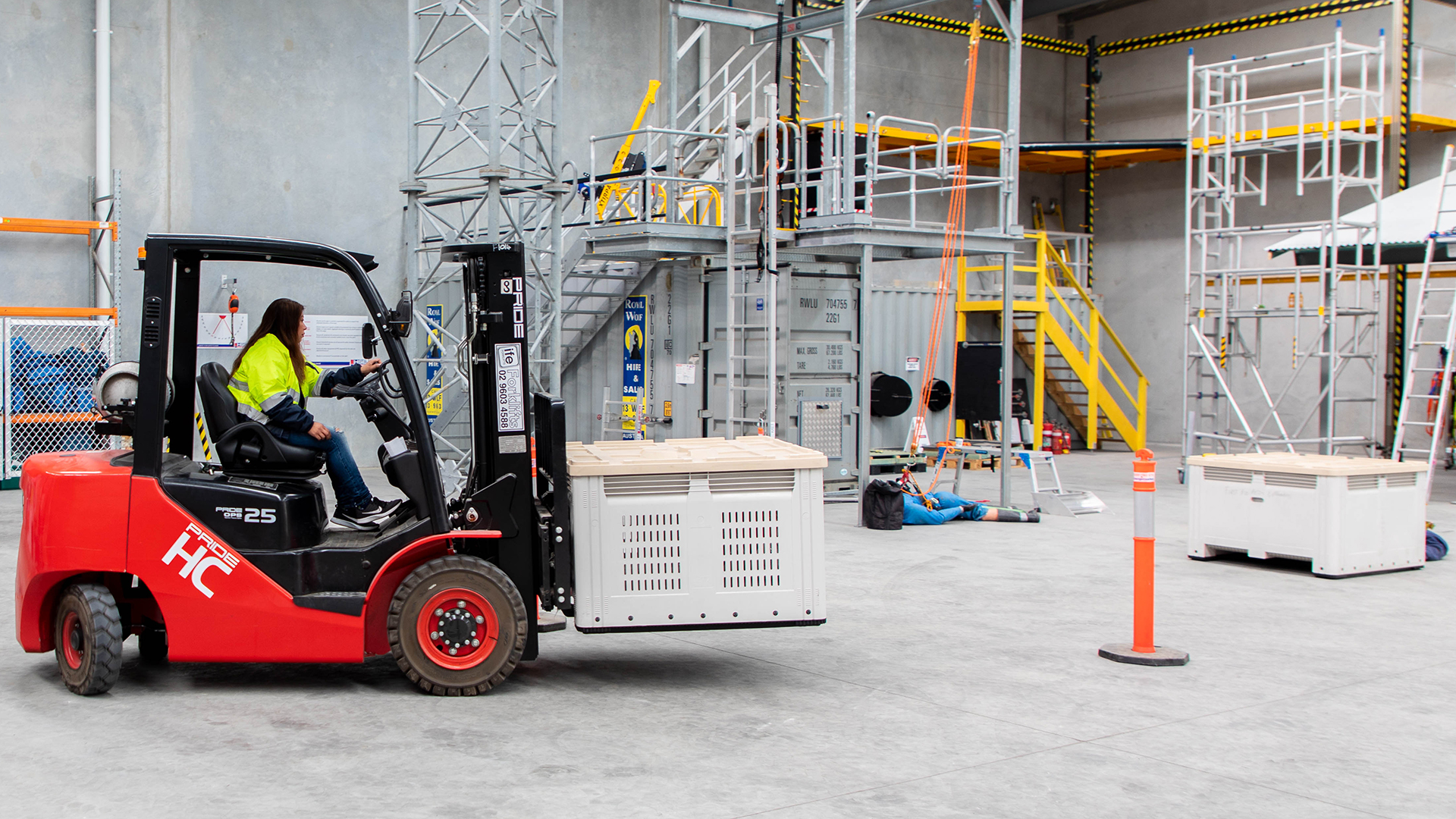 Participant moving large boxes around a warehouse using a forklift.