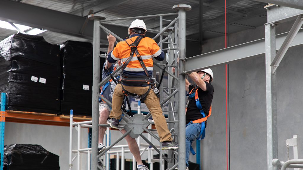 Work safely at heights training participants climbing a mock communications tower at HSE Sydney.