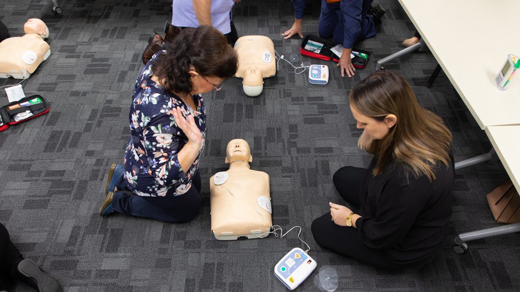 Participants in CPR training usising an automated external defibrillator (AEB)